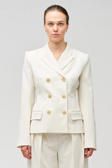 Profile view of model wearing the Oroton Shaped Double Breasted Blazer in Milk and 53% polyester, 42% virgin wool, 5% elastane for Women