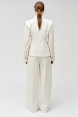 Profile view of model wearing the Oroton Slouch Pant in Milk and 53% polyester, 42% virgin wool, 5% elastane for Women