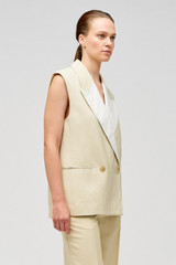 Profile view of model wearing the Oroton Sleeveless Waiter's Jacket in Limestone and 58% viscose, 42% linen for Women