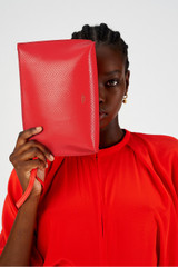 Profile view of model wearing the Oroton Mia Texture Pouch in True Red and Textured leather for Women