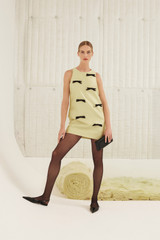 Profile view of model wearing the Oroton Bow Detail Shift Dress in Lemon Zest and 85% polyester, 15% silk for Women .
