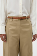 Profile view of model wearing the Oroton Florence 20MM Belt in Cognac and Premium smooth leather for Women .