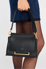 Profile view of model wearing the Oroton Elm Small Satchel Bag in Navy and Smooth Pebble Leather for Women .