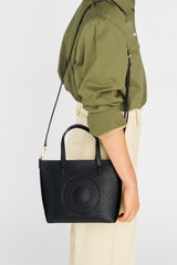 Profile view of model wearing the Oroton Polly Small Tote in Black and Pebble Leather for Women . IP:2