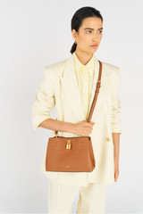 Profile view of model wearing the Oroton Tate Small Three Pocket Day Bag in Brandy and Pebble leather for Women