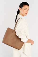 Profile view of model wearing the Oroton Polly Medium Zip Tote in Tan and Premium pebble leather for Women .