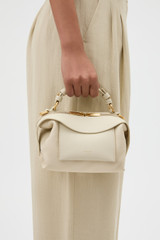 Profile view of model wearing the Oroton Mica Mini Bowler in Cashew and Pebble leather for Women .
