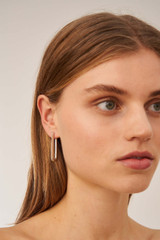 Profile view of model wearing the Oroton Lacey Large Hoops in Silver and Brass for Women .