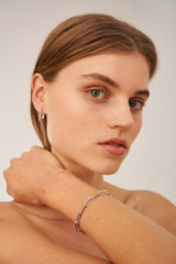 Profile view of model wearing the Oroton Lacey Medium Hoops in Silver and Premium brass material for Women .