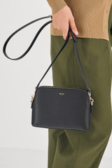 Profile view of model wearing the Oroton Iris Double Zip Crossbody in Black/Black and Premium pebble leather  for Women .
