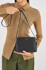 Profile view of model wearing the Oroton Iris Double Zip Crossbody in Black/Black and Premium pebble leather  for Women .