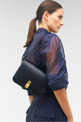 Profile view of model wearing the Oroton Etta Large Day Bag in Black and Premium smooth leather for Women .