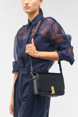 Profile view of model wearing the Oroton Etta Large Day Bag in Black and Smooth leather for Women