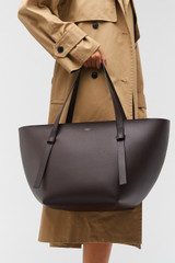 Profile view of model wearing the Oroton Ellis Medium Tote in Mahogany and Smooth leather for Women .
