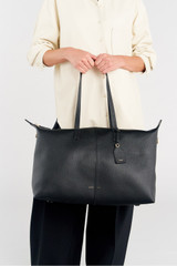 Profile view of model wearing the Oroton Lilly Weekender Tote in Black and Pebble leather for Women .