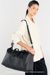 Profile view of model wearing the Oroton Lilly Weekender Tote in Black and Pebble leather for Women .