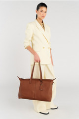 Profile view of model wearing the Oroton Lilly Weekender Tote in Cognac and Pebble leather for Women .