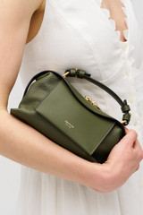 Profile view of model wearing the Oroton Mica Mini Bowler in Dark Khaki and Premium pebble leather for Women .