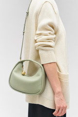Profile view of model wearing the Oroton Clara Mini Bag in Cactus and Pebble leather for Women .