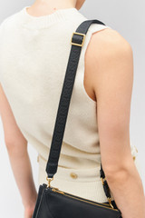Profile view of model wearing the Oroton Logo Narrow Webbing Strap in Black/Black and Smooth leather for Women .