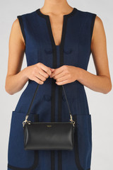 Profile view of model wearing the Oroton Harvey Baguette Crossbody in Black and Smooth leather for Women .