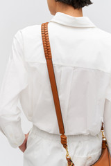 Profile view of model wearing the Oroton Florence Long Strap in Cognac and Smooth leather for Women .