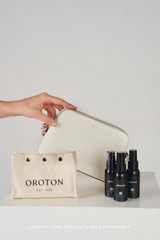 Profile view of model wearing the Oroton Iris Double Zip Crossbody in Cream and Premium pebble leather  for Women .