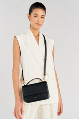 Profile view of model wearing the Oroton Lola Crossbody in Black and Textured Leather for Women .