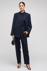 Profile view of model wearing the Oroton Pinstripe Blazer in North Sea and 95% WOOL 5% ELASTANE for Women .