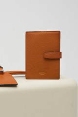 Profile view of model wearing the Oroton Fife Passport Sleeve in Amber and  for Women .