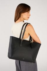 Profile view of model wearing the Oroton Dylan Large Tote in Black and Main body crafted from 100% pebble leather for Women .