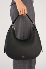 Profile view of model wearing the Oroton Dylan Hobo in Black and Premium pebble leather for Women .