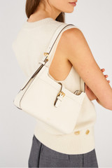 Profile view of model wearing the Oroton Dylan Baguette in Cream and Premium embossed leather for Women .