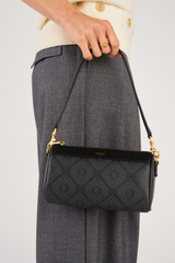 Profile view of model wearing the Oroton Harvey Signature Baguette Crossbody in Black and Nylon canvas base cloth material with PVC coating (70% PVC, 30% polyester) for Women .