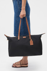 Profile view of model wearing the Oroton Lilly Nylon Weekender Tote in Black/Cognac and Nylon fabric for Women .