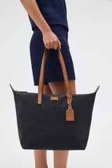 Profile view of model wearing the Oroton Lilly Nylon Light Weight Tote Bag in Black/Cognac and Nylon fabric for Women .