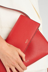 Profile view of model wearing the Oroton Eve Soft Fold Wallet in Dark Ruby and Premium pebble leather for Women .