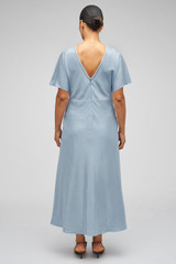 Profile view of model wearing the  Drape Front Dress in Denim Blue and 92% Silk 8% Spandex for Men