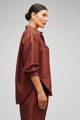 Profile view of model wearing the Oroton Ls Silk Shirt in Barn Red and 100% Silk for Women