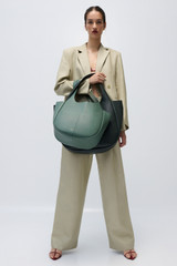 Profile view of model wearing the Oroton Pleat Pant in Laurel and 58% Viscose 42% Linen for Women . IP:2