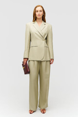 Profile view of model wearing the Oroton Wrap Blazer in Laurel and 58% Viscose 42% Linen for Women .
