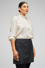 Profile view of model wearing the Oroton Spot Mini Skirt in Black/Cream and 100% Silk for Women .