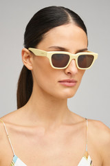 Profile view of model wearing the Oroton Pandora Sunglasses in Custard and Acetate material for Women .