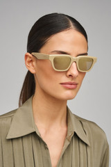 Profile view of model wearing the Oroton Pandora Sunglasses in Wheat and Acetate material for Women .