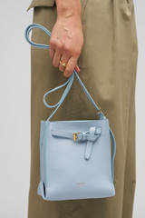 Profile view of model wearing the Oroton Margot Tiny Bucket Bag in Denim and Smooth Leather exterior for Women