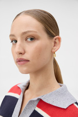 Profile view of model wearing the Oroton Leah Charm Hoop Earrings in Gold and Brass for Women .