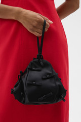 Profile view of model wearing the Oroton Miette Mini Bag in Black and Polyester satin material for Women .