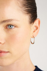 Profile view of model wearing the Oroton Nicole Large Stud Hoop in Silver and Stainless Steel for Women .