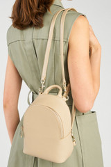 Profile view of model wearing the Oroton Inez Mini Backpack in Fawn and Premium saffiano leather for Women .