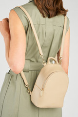 Profile view of model wearing the Oroton Inez Mini Backpack in Fawn and Premium saffiano leather for Women .